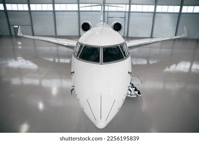 Exclusive and Artistic Capture of a Private Jet Being Serviced in a Modern Hangar. Expensive and luxury trip is waiting after a passengers. Business jet prepared for departure - Shutterstock ID 2256195839