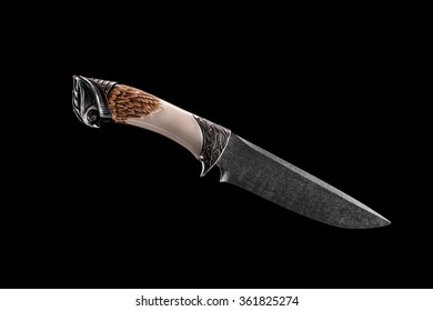 Exclusive knife with a handle made of ivory on the black background