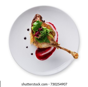 Exclusive restaurant meals. Duck confit with braised cabbage, baked apple and cranberry sauce, isolated on white background, top view