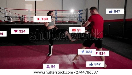 Executing athlete in gray top, shin guards kicking trainer in ring with focus mitts, social-icons. Sparring, boxing, fighter, coach, gym, kickboxing, pads