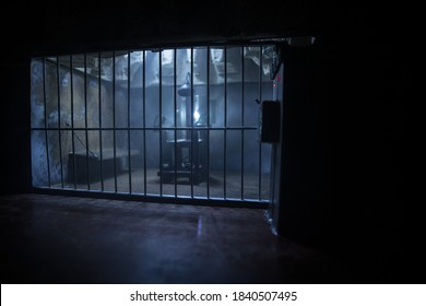 Execution concept. Death penalty electric chair miniature in selective focus inside old prison. Old prison bars cell lock. Creative artwork decoration. Electric chair scale model in the dark
