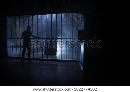 Execution with Lethal injection concept. Death penalty lethal injection table miniature inside old prison. Old prison bars cell lock. Prisoner in the jail. Old grunge prison interior.