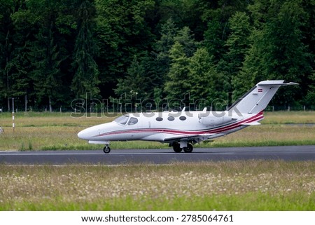 Executive aircraft photographed from the side while moving across the airfield creating a clean aviation composition with natural copy space