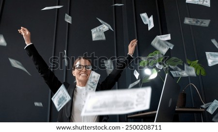 Executive celebrating money rain in her office, enjoying a bonus or successful deal. Perfect for themes of business success, financial achievement, and professional triumph.