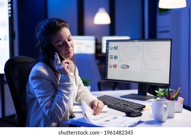 Executive entrepreneur talking at smartphone with employee creates new marketing concept in business office. Busy manager using modern technology network sitting at desk late at night - Shutterstock ID 1961482345