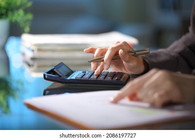 Executive hands calculating using calculator in the night at office - Shutterstock ID 2086197727