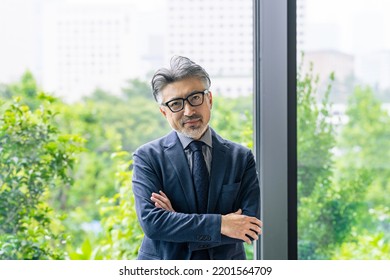 Executive man standing in front of natural green. - Shutterstock ID 2201564709