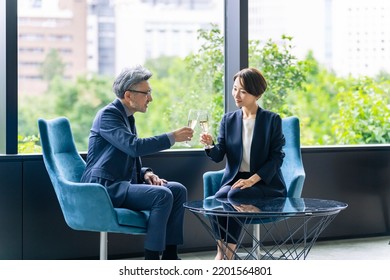 Executive man and woman chatting while drinking champagne in the lobby. celebration party. - Powered by Shutterstock