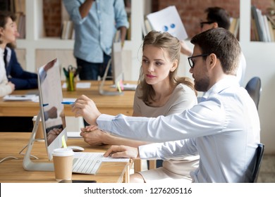 Executive manager mentor teaching intern employee giving instructions showing new online project pointing on computer screen, serious worker helping explain colleague listen work task look at monitor - Shutterstock ID 1276205116