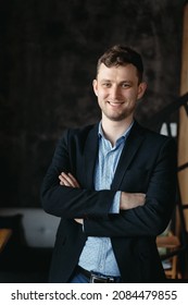 Executive manager portrait looking at camera standing in modern loft space.