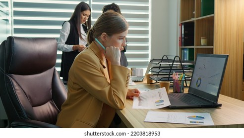 Executive manager taking notes on financial documents to create data charts with sales statistics. Accountant analyzing research papers and report on laptop for business development.
