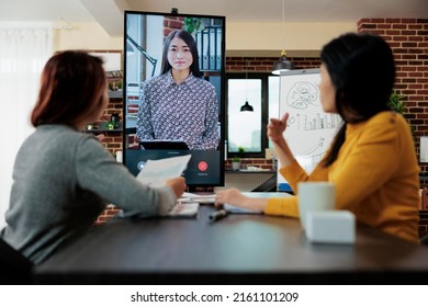 Executive Managers Collaborating Together At Management Project Discussing Business Ideas During Online Videocall Meeting Conference In Startup Office. Teleconference Call On Monitor Screen