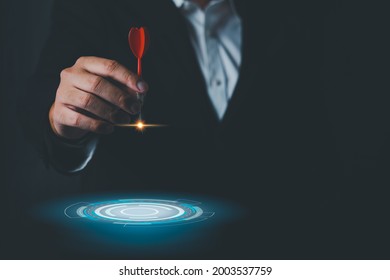 Executive marketing Businessman hand holding red arrow dart and throwing to the center of virtual target dart board. objectives Business investment goal and target for business investment concept.
