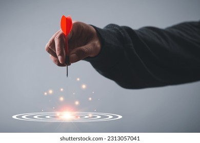 Executive marketing Businessman hand holding red arrow dart and throwing to the center of virtual target dart board. objectives Business investment goal and target for business investment concept. - Shutterstock ID 2313057041