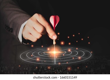 Executive marketing hand holding red dart put to centre of target board. Business investment goal and target concept. - Shutterstock ID 1660151149