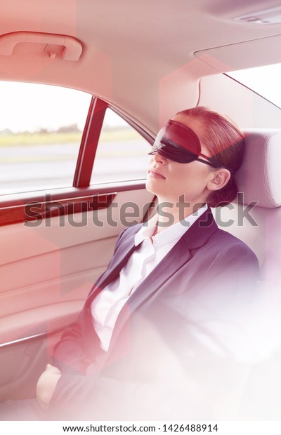 Executive with\
mask napping in car during\
travel