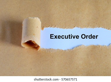 Executive Order Word Written Under Ripped And Torn Paper.