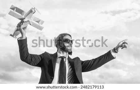 executive in suit and pilot hat launch plane toy