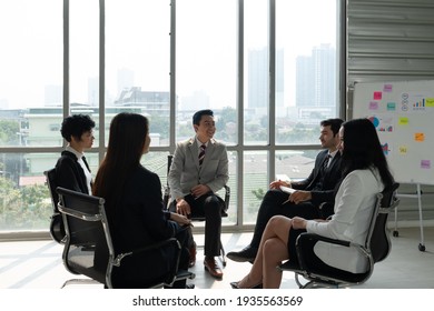 Executive Talking With Professional Business Team Including Caucasian And Asian People About Leadership In Company. Diversity In Business Concept