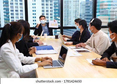 Executive Team Meeting During Coronavirus Or Covid-19 For Business New Financial Strategy After Pandemic With All Staff Members Wearing Facial Mask As Of New Normal And Social Distancing Policy