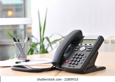 Executive VoIP phone on a beech desk