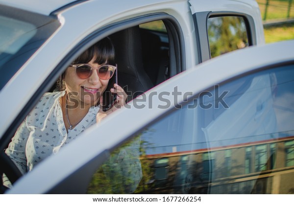 \
executive woman with glasses talking on the phone\
in the car
