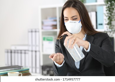 Executive woman wearing protective mask using hand sanitizer on a desk at office - Powered by Shutterstock