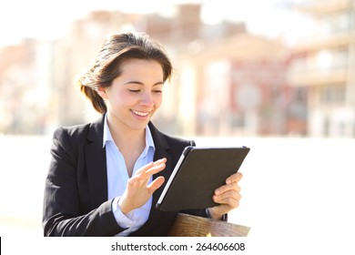 Executive working browsing a tablet in a park sitting in a bench - Powered by Shutterstock