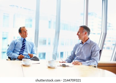 Executives In Casual Meeting Over Coffee. Two Business Men Having Casual Meeting Indoors At Table.