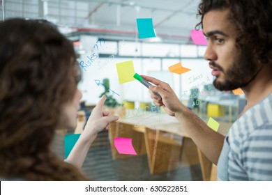 Executives discussing over sticky notes in creative office - Shutterstock ID 630522851