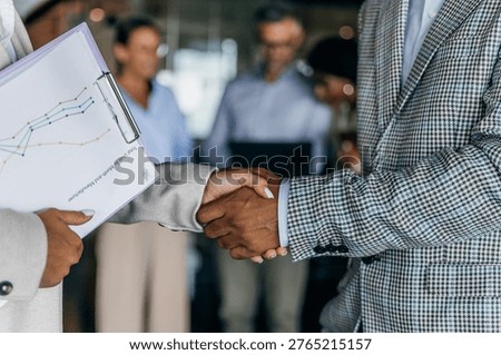 Executives in formal attire conclude agreement securely