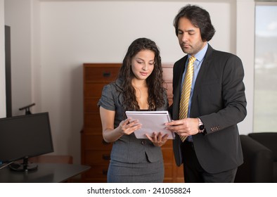 Executives standing reviewing a document