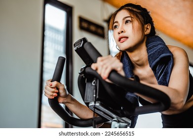 Exercise bike cardio workout at fitness gym.Asian women doing sport biking in the gym for fitness in the morning.Fitness,Gym ,healthy lifestyle concepts. - Shutterstock ID 2245656515