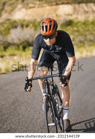 Exercise, bike and cycling with a sports man on a road through the mountain for cardio or endurance. Fitness, workout or training with a male cyclist riding his bicycle on an asphalt street in nature