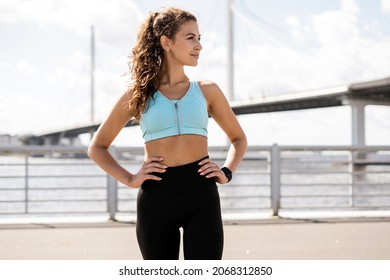 Exercise coach on the street, healthy lifestyle. A woman does a stretching workout. An athlete in sportswear, fitness in the city. - Powered by Shutterstock