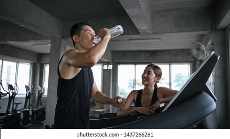 Exercise concept. The young woman is delivering drinking water to the athletes. - Powered by Shutterstock