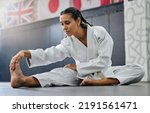 Exercise, fight and workout stretch of a karate school student with focus before training start. Sport woman or coach stretching for an exercise at a dojo studio, performance gym or martial arts