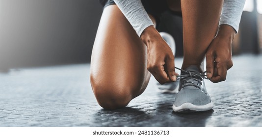 Exercise, hands and person tie shoes to start training or workout at health club on floor. Legs, athlete and tying lace on sneakers to prepare or getting ready for sport, fitness or wellness in gym - Powered by Shutterstock