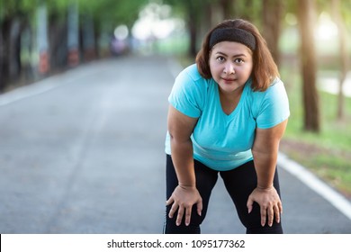 Exercise and healthy concept : Fat woman feeling tired while running in the park