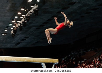 exercise on balance beam gymnastics, female gymnast perform backward somersault landing on floor - Powered by Shutterstock