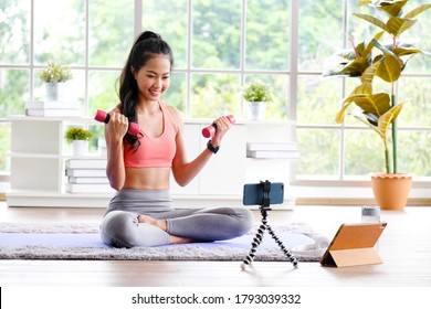 Exercise Online Training Class At Home, Asian Girl Holding Dumbbell For Workout Fitness, Healthy Asia Woman Training  Exercise By Mobile Phone, Female Sport Blogger Recording Video By Smartphone