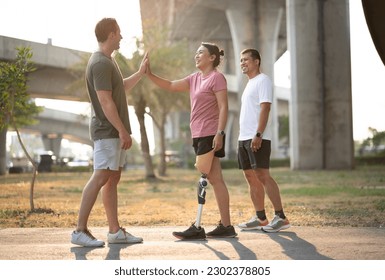 Exercise walking Asia woman with  prosthetic leg and hi five to friend in the park	 - Powered by Shutterstock