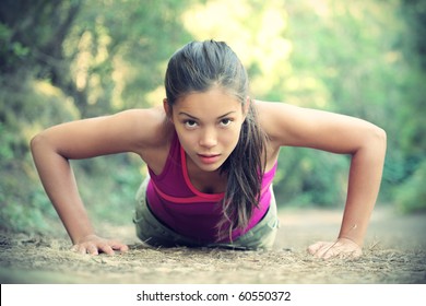 Exercise woman doing push-ups outdoors in the forest, Beautiful young female athlete.