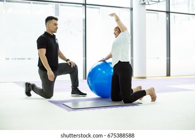 Exercising In Gym With Ball With PT