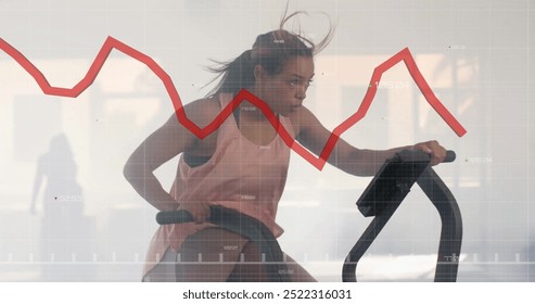 Exercising on stationary bike, woman with stock market graph image over. Fitness, exercise, cycling, technology, investment, data visualization - Powered by Shutterstock