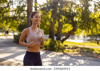 Exercising outdoors is healthy for active lifestyle runners. Autumn trail run woman running in nature from behind in dark forest. Outdoor jog. Pretty sporty woman jogging at park in sunrise light - Powered by Shutterstock