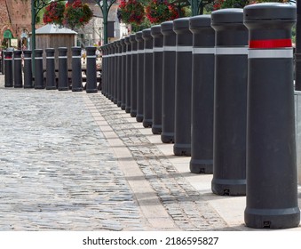 Exeter, Devon, Uk. August 4th 2022. Line Of Large Black Bollards With Red And White Reflective Banding. Road Safety And Traffic Management. Dividing A Cobbled Pedestrianized Area From A Road.