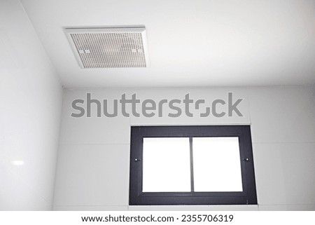 The exhaust fan is installed on the ceiling near the skylight.
