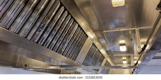 Exhaust hood interior showing shiny stainless steel grease filters and lights - Shutterstock ID 2152813535