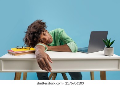Exhausted african american male student sleeping at desk with books and laptop, guy napping at table feeling tired after study online and busy schedule - Powered by Shutterstock